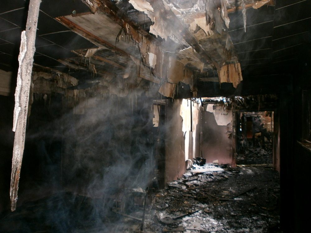 A secondary view of charred structural columns and cleanup